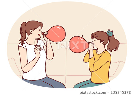 Mother and daughter inflate balloons sitting on sofa to decorate apartment for birthday party Mother and daughter inflate balloons sitting on sofa to decorate apartment for birthday party 135245378