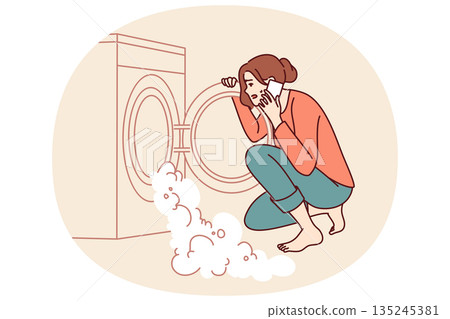 Woman near broken washing machine calls home electronics repairman because of foam pouring out drum Woman near broken washing machine calls home electronics repairman because of foam pouring out drum 135245381