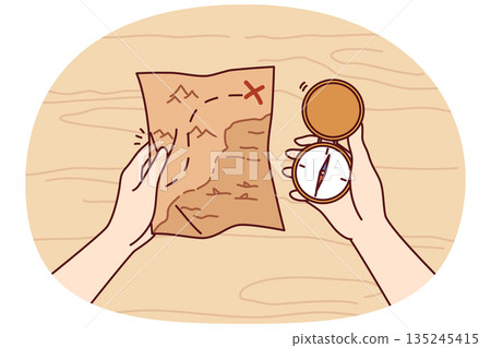 Treasure map and compass in hands of man looking for expensive jewels lost at sea from pirate ships 135245415