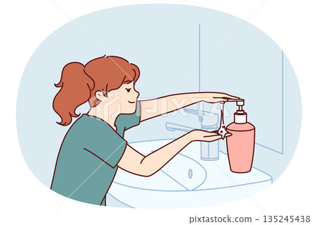 Little girl uses liquid soap to wash hands standing near sink and mirror in bathroom Little girl uses liquid soap to wash hands standing near sink and mirror in bathroom 135245438