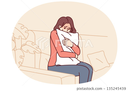 Frightened woman hugging pillow sitting on couch feeling fear and depressed psychological state Frightened woman hugging pillow sitting on couch feeling fear and depressed psychological state 135245439