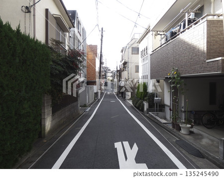A quiet residential street with sunlight streaming in. A straight, deep alleyway and everyday Japanese scenery. A quiet residential street with sunlight streaming in. A straight, deep alleyway and everyday Japanese scenery. 135245490