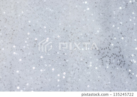 Shimmering silver sequin fabric background with soft sparkle for festive and fashion styling Demonstrating Pantone color of the year 2026 - Cloud Dancer 135245722