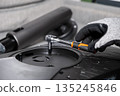 Gloved hand skillfully using a ratchet wrench to tighten components on an electronic device, highlighting precision, assembly, repair, and technical service 135245846