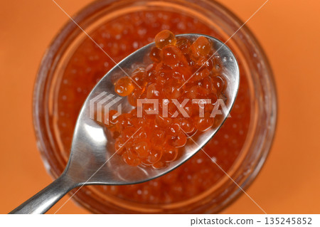 Red trout caviar on a silver spoon 135245852