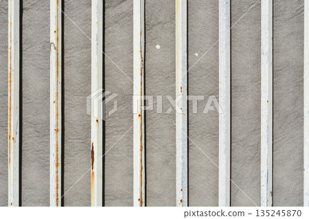 Vertical Rusty Metal Bars Against Stone Background 135245870