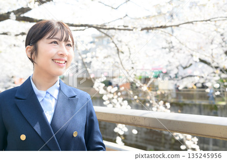 Japanese woman looking up at cherry blossoms Japanese woman looking up at cherry blossoms 135245956