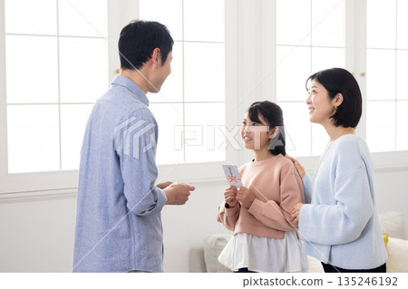An elementary school girl receiving a New Year's gift from a man An elementary school girl receiving a New Year's gift from a man 135246192