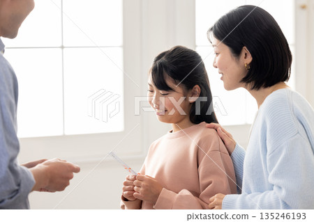 一位小學生收到一位男士贈送的新年禮物 135246193