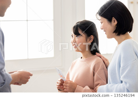 一位小學生收到一位男士贈送的新年禮物 一位小學生收到一位男士贈送的新年禮物 135246194