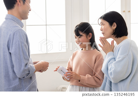 An elementary school girl receiving a New Year's gift from a man An elementary school girl receiving a New Year's gift from a man 135246195