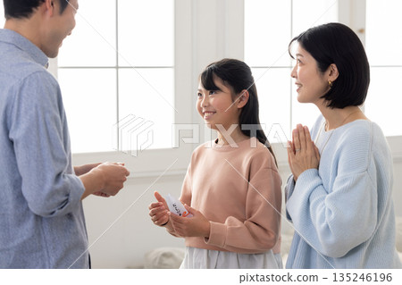 An elementary school girl receiving a New Year's gift from a man An elementary school girl receiving a New Year's gift from a man 135246196