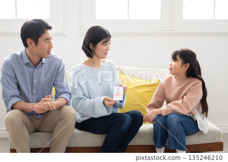 一位笑容燦爛的小學生從父母那裡收到了新年壓歲錢。 135246210