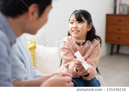 一位笑容燦爛的小學生從父母那裡收到了新年壓歲錢。 一位笑容燦爛的小學生從父母那裡收到了新年壓歲錢。 135246216