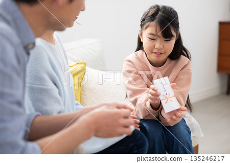 一位微笑的小學生正在查看她的新年禮物。 一位微笑的小學生正在查看她的新年禮物。 135246217