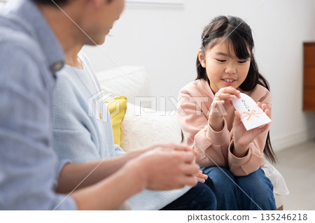 一位微笑的小學生正在查看她的新年禮物。 135246218