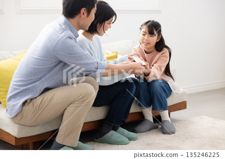 一位笑容燦爛的小學生從父母那裡收到了新年壓歲錢。 135246225