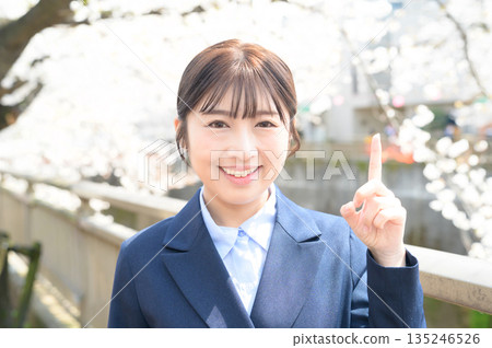 Woman pointing at cherry blossoms Woman pointing at cherry blossoms 135246526