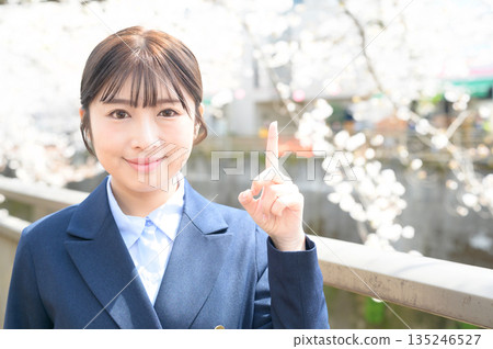 Woman pointing at cherry blossoms Woman pointing at cherry blossoms 135246527