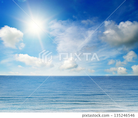 Serene ocean landscape under a bright sun and blue sky. Serene ocean landscape under a bright sun and blue sky. 135246546