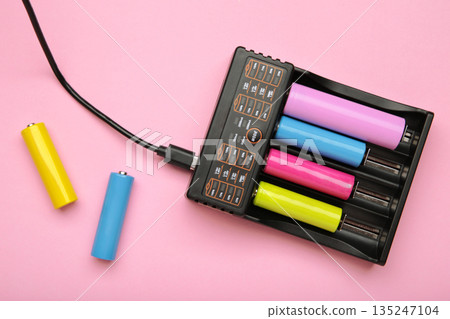 Rechargeable batteries in a battery charger. Four batteries in a charger. NI-MH and LI-MH battery. 135247104