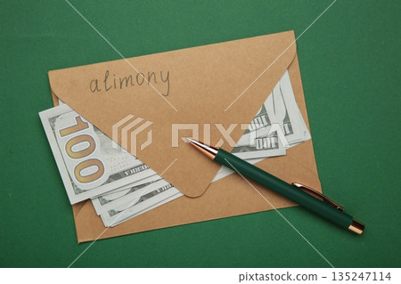 Envelope with word Alimony and money on green background. 135247114