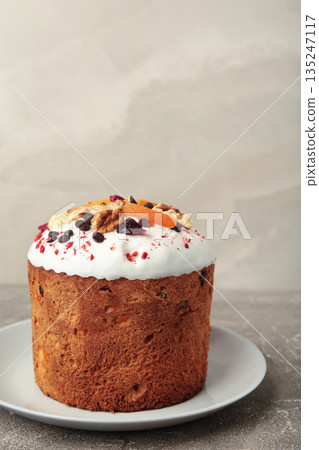 Traditional easter cakes with colorful sprinkles, with eggs on grey background. Vertical photo 135247117