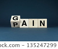 Wooden blocks spelling Gain - Pain 135247299
