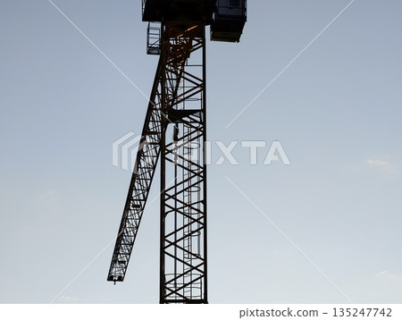 crane silhouette ready, dramatic scene of tower crane prepared for lifting operations against pale 135247742
