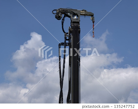 drill mast against sky with maintenance gear, industrial drill mast under blue sky with tools drill mast against sky with maintenance gear, industrial drill mast under blue sky with tools 135247752