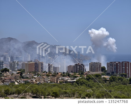 coastal city with rising smoke, urban coastal scene enveloped by thick smoke and distant mountains 135247768