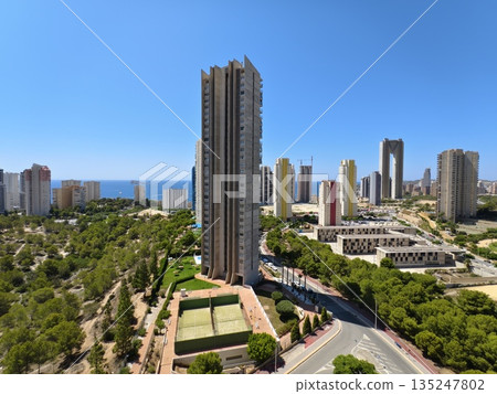 bright tower overlooks lively park, sunlit building overlooking vibrant green space and sea 135247802