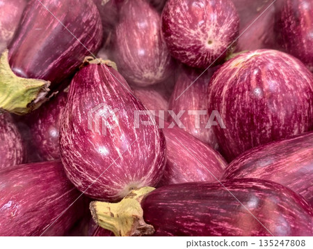 vivid eggplant display, closeup of shiny eggplants highlighting rich textures and rustic lighting vivid eggplant display, closeup of shiny eggplants highlighting rich textures and rustic lighting 135247808