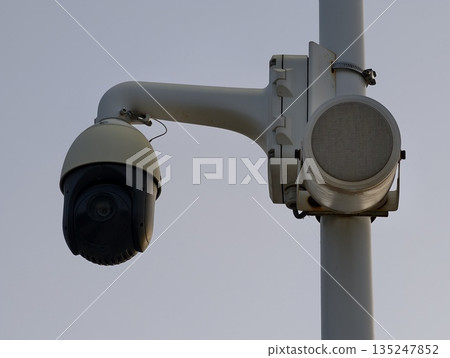 advanced security camera installed on pole overseeing city intersection at dusk for safety advanced security camera installed on pole overseeing city intersection at dusk for safety 135247852