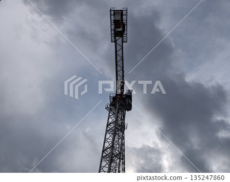 urban crane outline against turbulent sky, silhouette of crane towering over stormy city streets urban crane outline against turbulent sky, silhouette of crane towering over stormy city streets 135247860