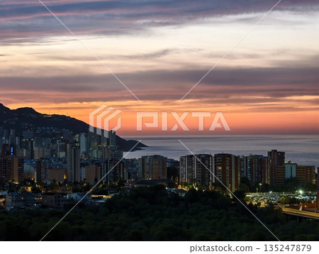 evening horizon with silhouettes, serene evening seaside scene featuring glowing sky and distant 135247879