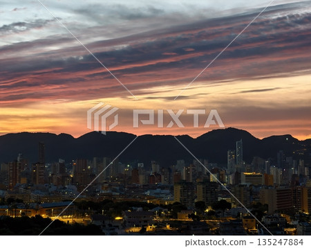 sunset hues blend with towering city silhouettes, twilight colors streak across sky with urban sunset hues blend with towering city silhouettes, twilight colors streak across sky with urban 135247884
