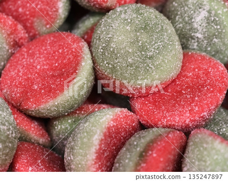 detailed macro image capturing lively red and green gummy discs coated in crystallized sugar 135247897