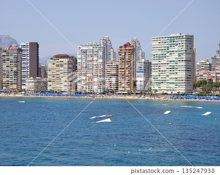 Vivid seaside scene with speedboats and distant cityscape Vivid seaside scene with speedboats and distant cityscape 135247938