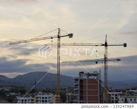 Dusk paints industrial structures against mountain backdrop Dusk paints industrial structures against mountain backdrop 135247984