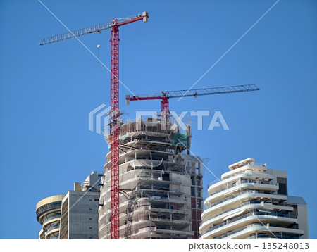 Refined residential tower being built amidst vibrant cityscape 135248013