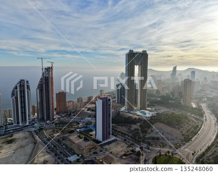dramatic dawn illuminates coastal structures with golden rays piercing morning fog and tranquil reflections dramatic dawn illuminates coastal structures with golden rays piercing morning fog and tranquil reflections 135248060