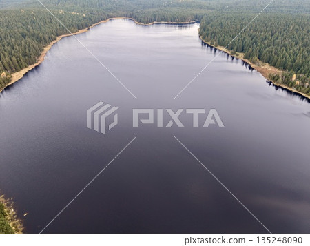 wilderness scene overview, expansive shadowed water body surrounded by dense forestry landscape wilderness scene overview, expansive shadowed water body surrounded by dense forestry landscape 135248090
