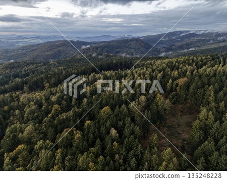 Sweeping Aerial Perspective Of Mountain Woodland With Layered Ridges And Atmospheric Clouds Sweeping Aerial Perspective Of Mountain Woodland With Layered Ridges And Atmospheric Clouds 135248228