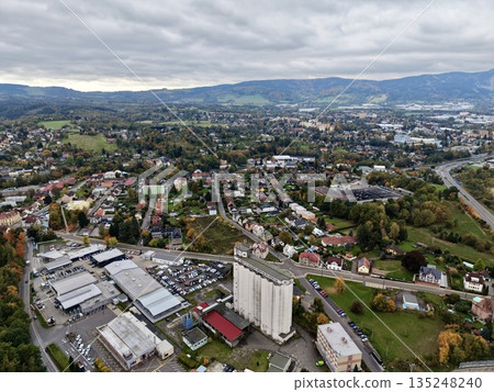 Urban Tower Amidst Shops And Hills, Commercial Structure Surrounded By Residential Areas And Nature 135248240