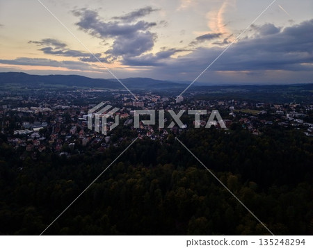 Evening Glow Over Quiet City, Twilight Glow Bathes City Towers With Soft Warm Illumination At Dusk Evening Glow Over Quiet City, Twilight Glow Bathes City Towers With Soft Warm Illumination At Dusk 135248294