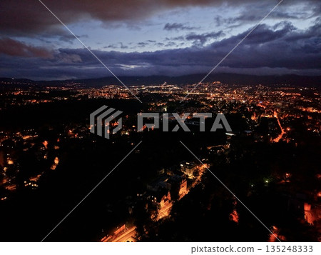Urban Streets Shimmer At Night, Vivid Arterial Routes Illuminate Metropolitan Area With Vibrant Glow 135248333