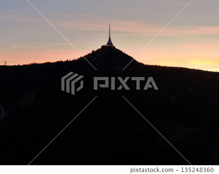 Modern Tower With Signal Themes, Cityscape Featuring Spire Silhouette And Glowing Horizon At Sunset Modern Tower With Signal Themes, Cityscape Featuring Spire Silhouette And Glowing Horizon At Sunset 135248360