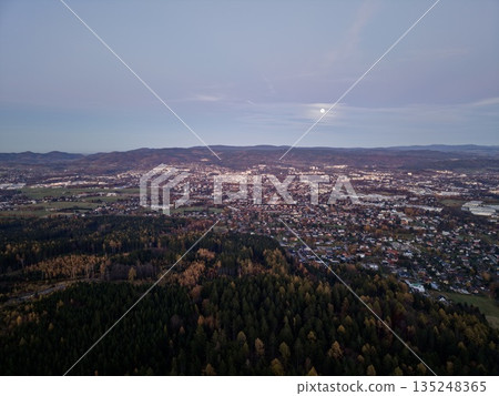 Bright Moon Over Expansive Woodland With Distant City Lights Creating Peaceful Night Scenery Bright Moon Over Expansive Woodland With Distant City Lights Creating Peaceful Night Scenery 135248365