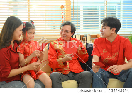Asian grandparents giving red envelope to descendants during Chinese New Year family reunion Asian grandparents giving red envelope to descendants during Chinese New Year family reunion 135248994